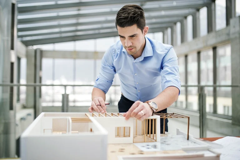 Estudiante revisando planos arquitectónicos en una universidad – Explora los mejores posgrados de arquitectura en México